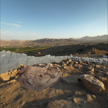 The view of Ararat Plain Southeast Archaeological Project site from within the MR headset, where both a grey stone wall and a brown pottery vessel are virtually visible in their original positions, even though they were actually removed a year earlier. (Photo credit: HKU Faculty of Arts)